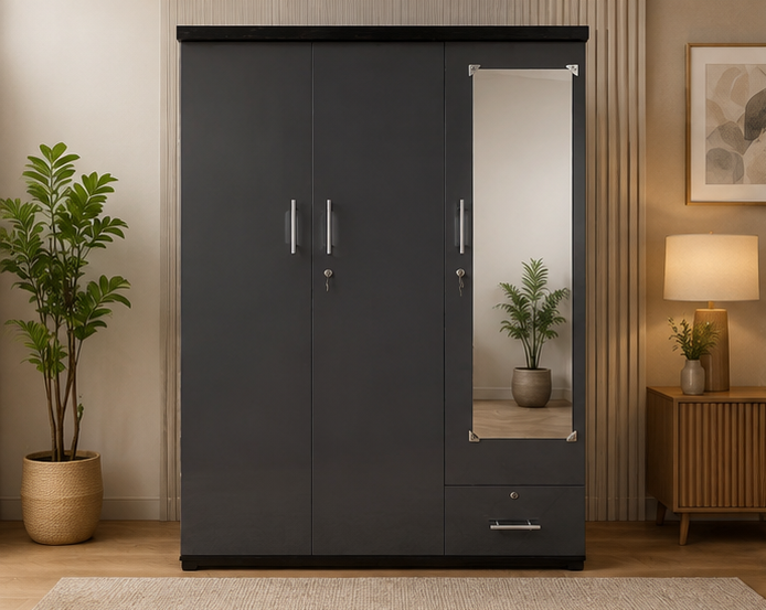 A modern dark gray three-door wardrobe with a mirrored door and a single drawer, styled in a warm, contemporary bedroom setting with a wooden side table, lamp, and potted plant.
