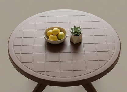 Round table with a bowl of lemons and a small plant on a plain background