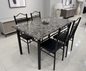 Dining table set with marble-like top and black chairs in a modern room.