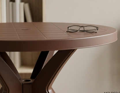 Round brown table with a pair of glasses on top, blurred background
