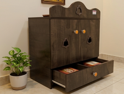Wooden pet cabinet with multiple drawers and pet door designs, next to a potted plant.