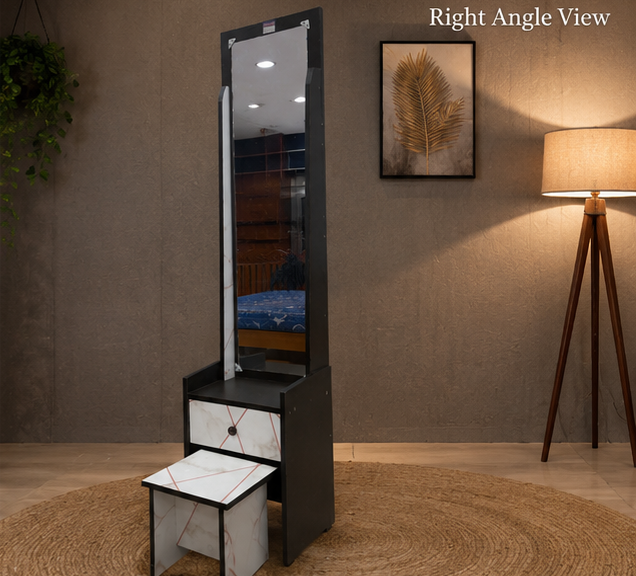 Black tall mirror with two drawers in a room with a lamp and wall art.