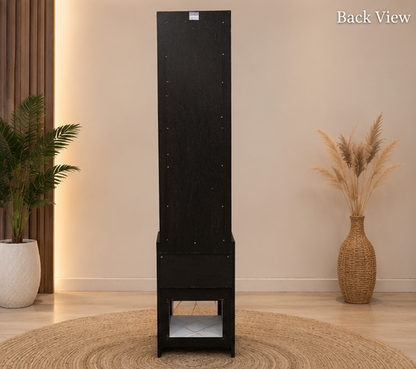 Black tall cabinet with a plant and vase on a wooden floor and beige wall