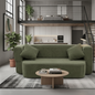 Green sofa in a modern living room with a coffee table and plants.