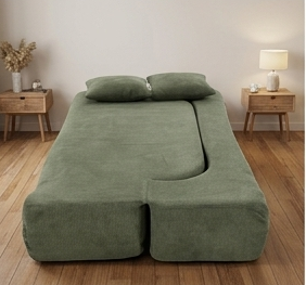 Green sofa in a modern living room with a coffee table and plants.